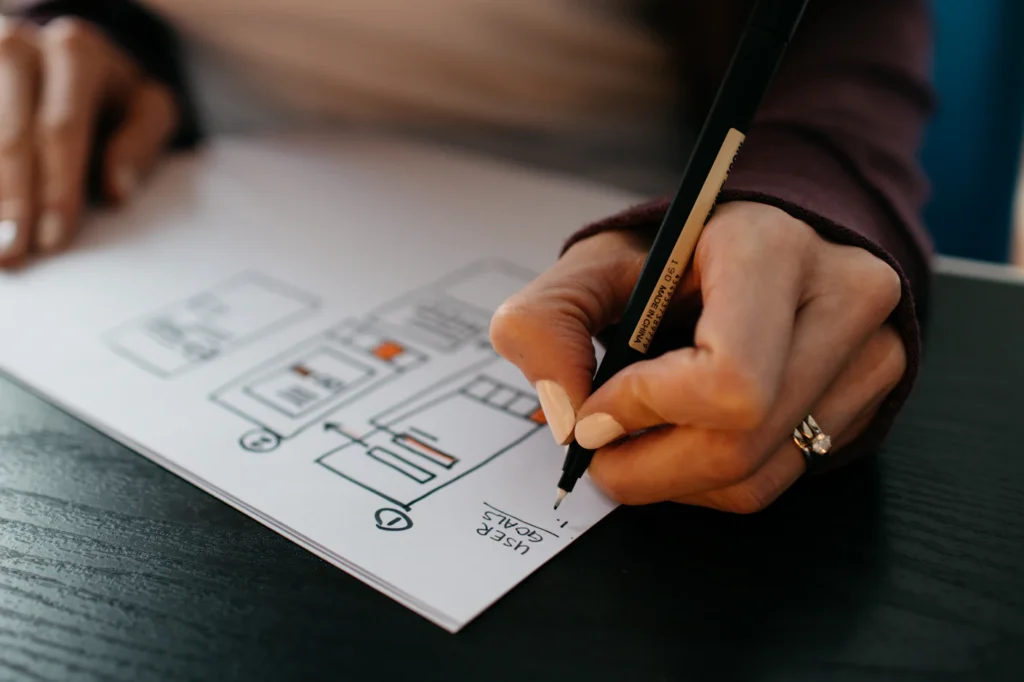 Designer sketching website wireframes on paper